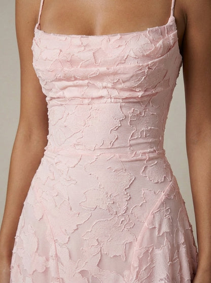 Detail shot of blush pink maxi dress fabric with textured floral pattern across waist and bodice