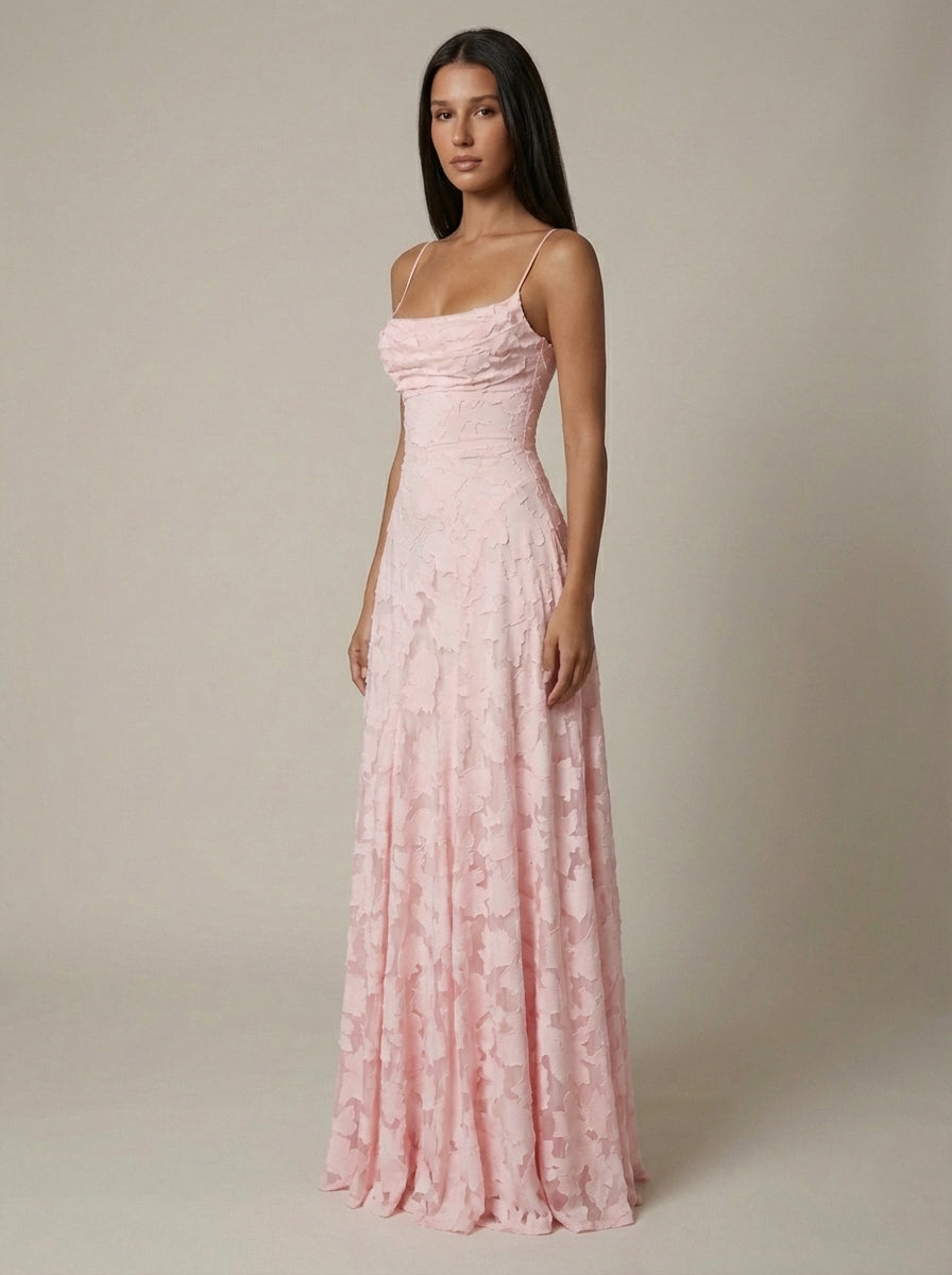 Side angle of blush pink maxi dress with slim straps, fitted waist, and softly draped skirt