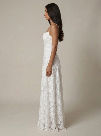 Side profile of white lace maxi dress showing slim fit through waist and flowing A-line skirt