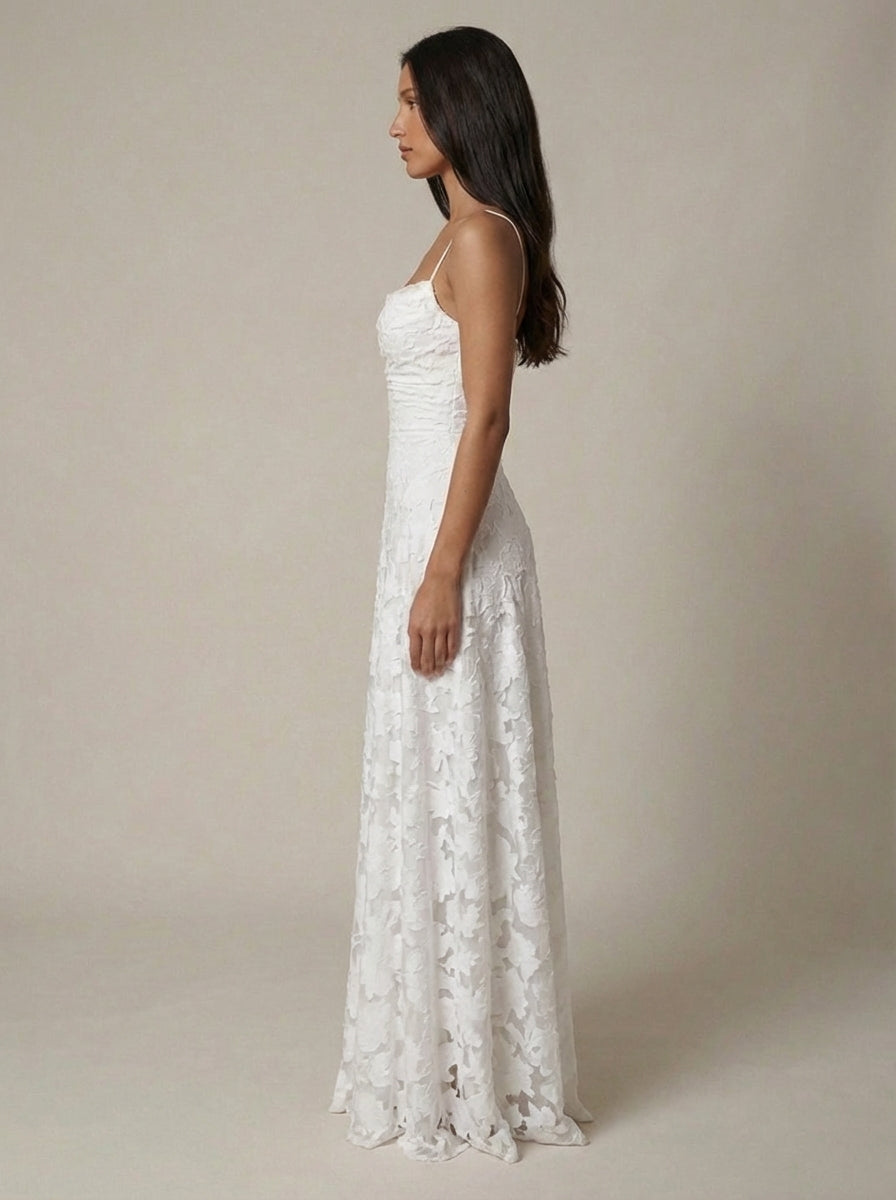 Full-length side view of white floral lace maxi dress with thin straps and soft drape at hem