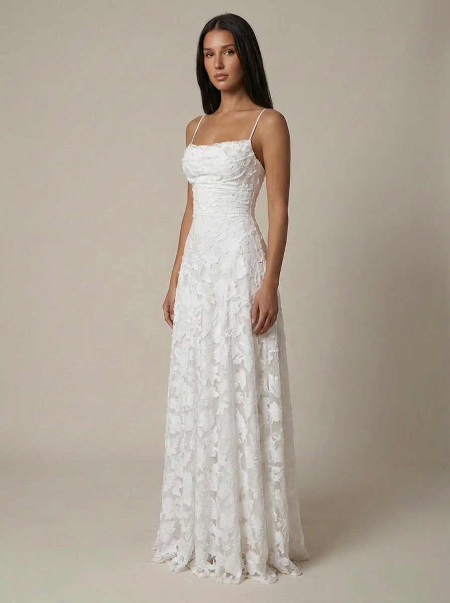 Three-quarter view of white maxi dress with straight neckline and floral lace texture, full-length fit