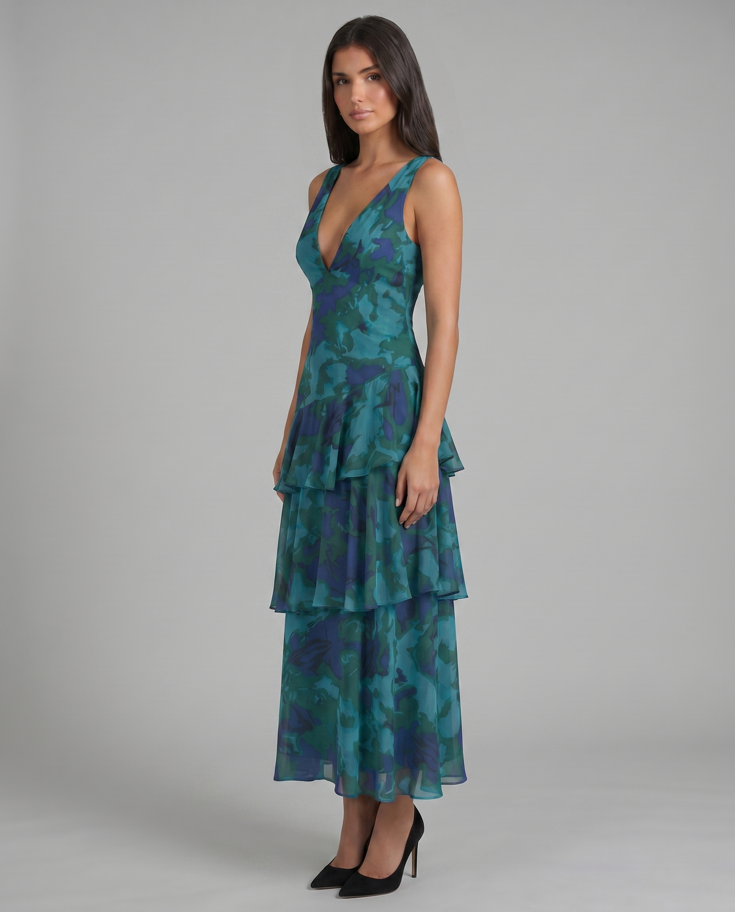 Three-quarter side view of blue abstract print maxi dress with plunging neckline and layered skirt