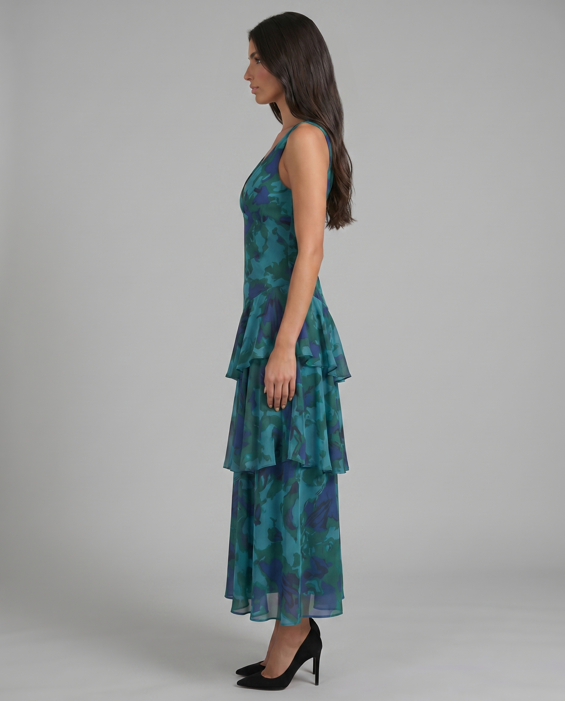 Side profile of blue sleeveless maxi dress showing flowy chiffon fabric and double-tier ruffle detail