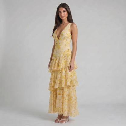 Angled view of yellow floral maxi dress with plunging neckline and layered tiered skirt