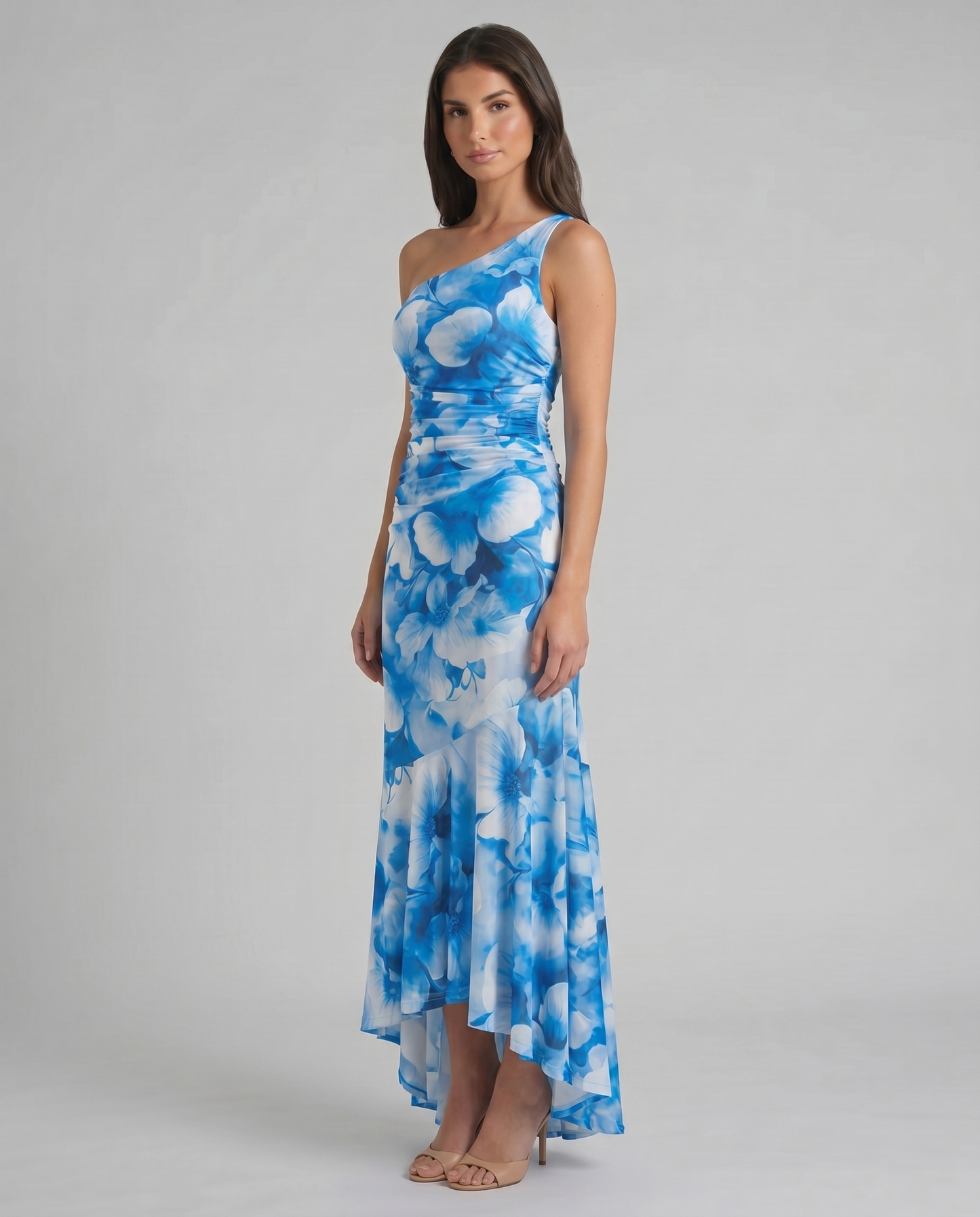 Three-quarter view of blue floral one-shoulder maxi dress featuring fitted waist ruching and flared hem