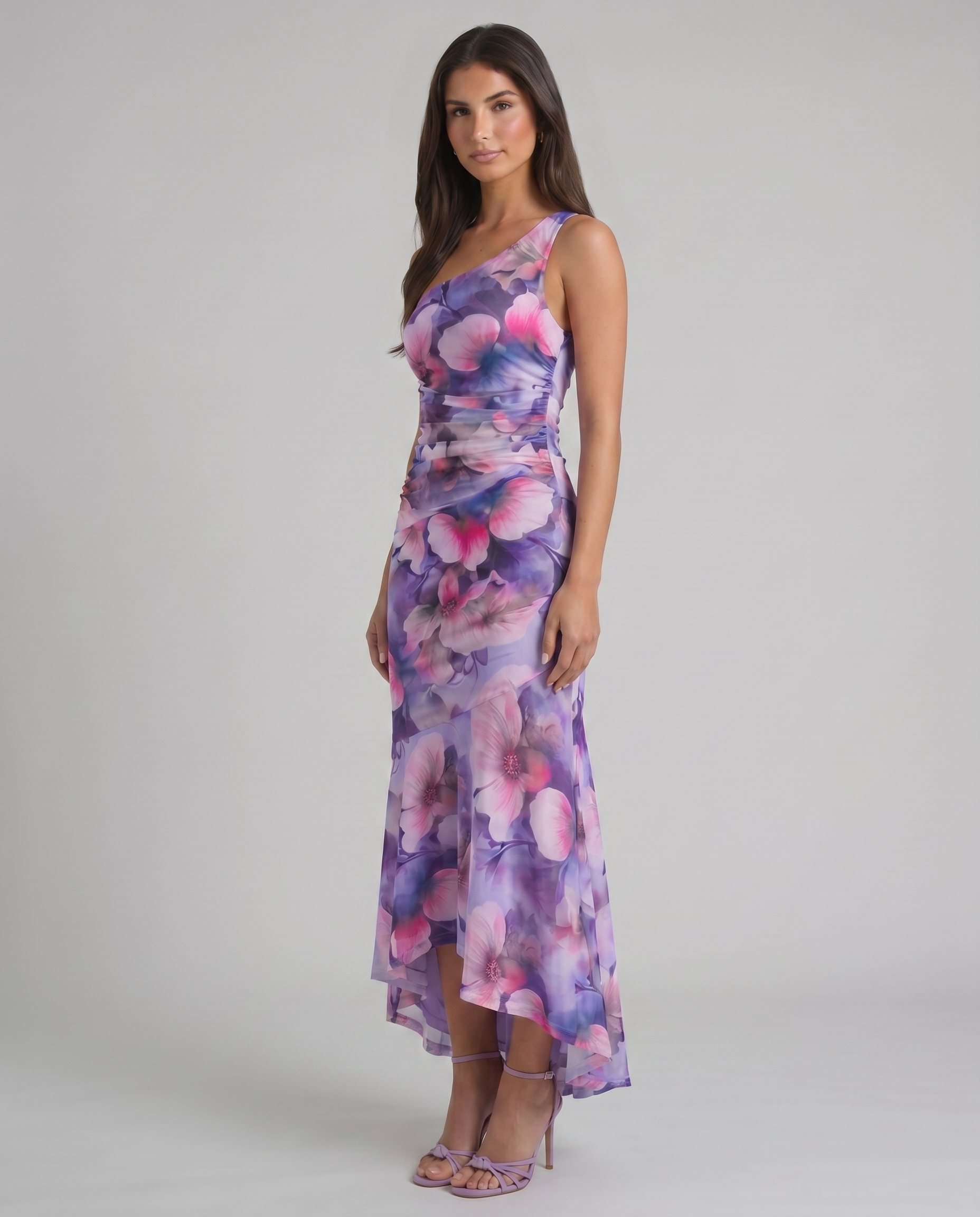 Purple floral maxi dress in angled view showing one-shoulder neckline, fitted ruching, flowy skirt