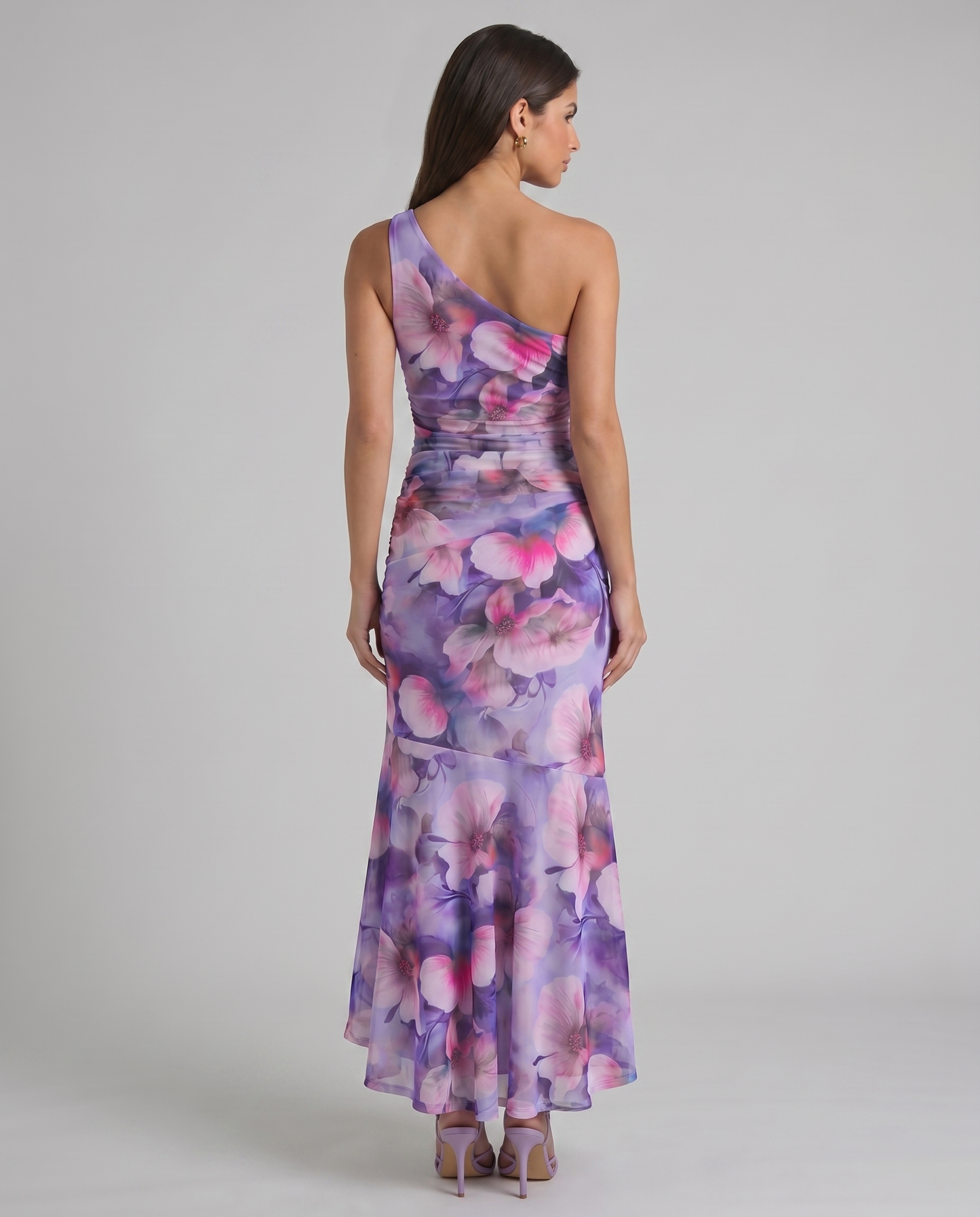 Back view of purple floral one-shoulder maxi dress with fitted waist and flowing high-low skirt