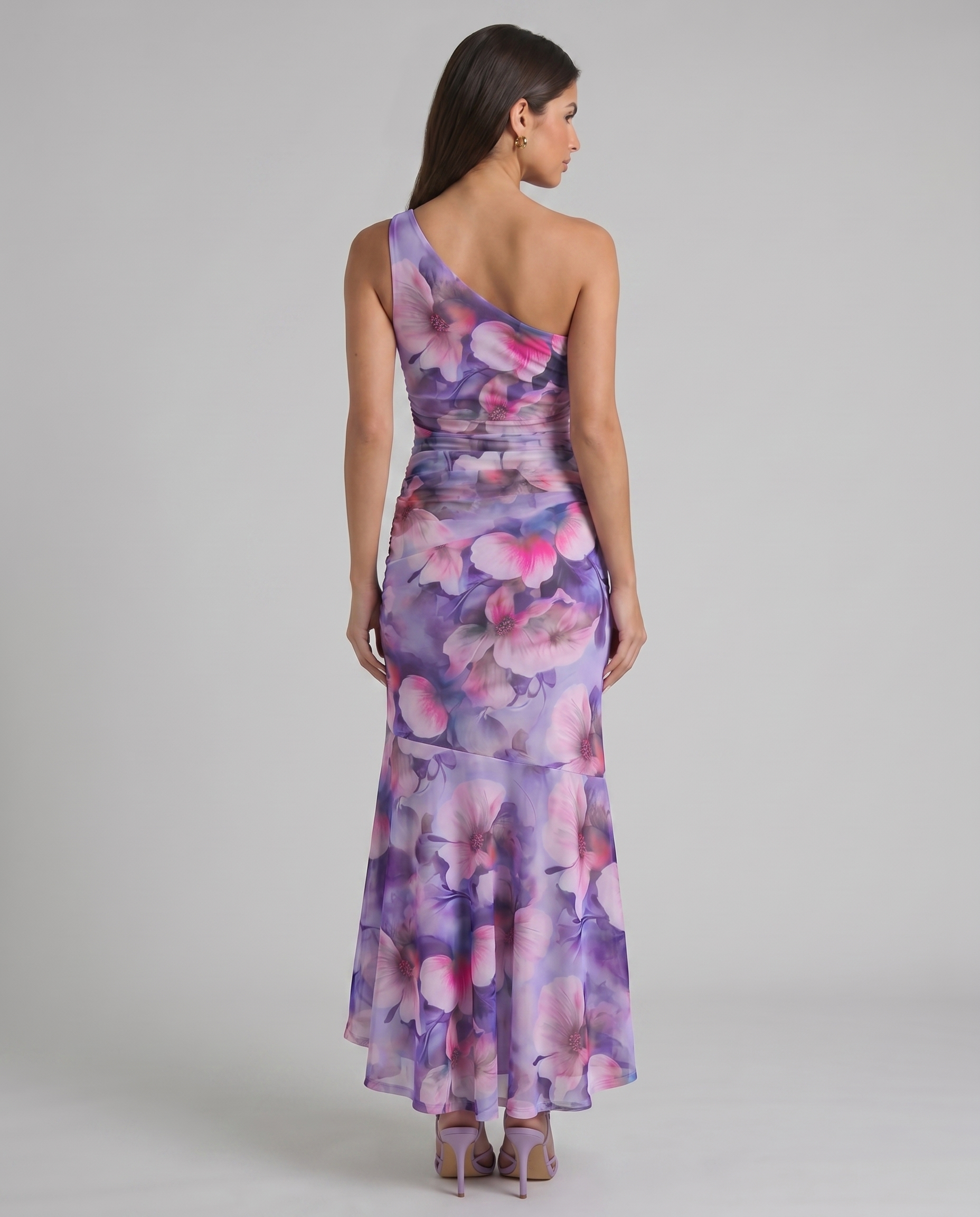 Back view of purple floral one-shoulder maxi dress with fitted waist and flowing high-low skirt