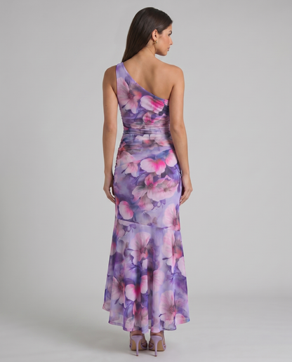 Back view of purple floral one-shoulder maxi dress with fitted waist and flowing high-low skirt