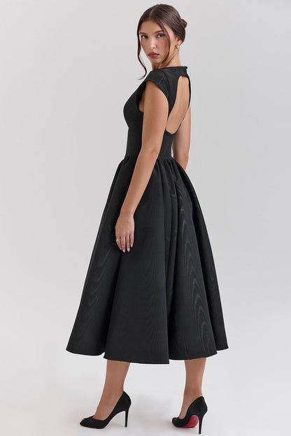 Side view black midi dress with open back cutout, cap sleeves and full skirt, midi length