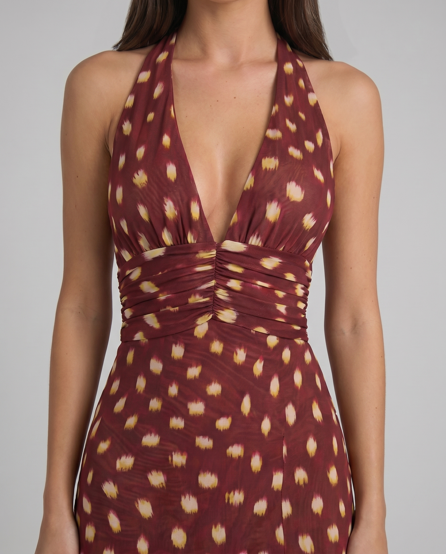 Close-up of burgundy multicolor halter mini dress showing deep V neckline and ruched waistband