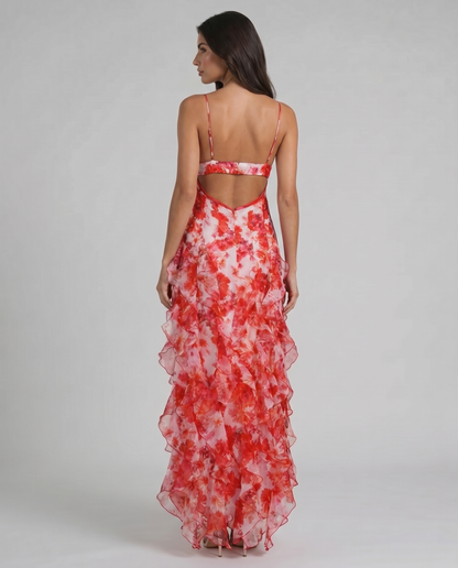 Back view of red floral maxi dress with open back cutout, thin straps, and ruffled skirt