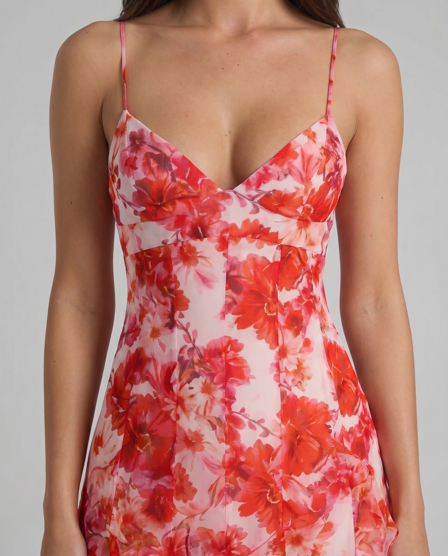 Close-up of red floral maxi dress bodice with v-neckline, seam detailing, and thin straps