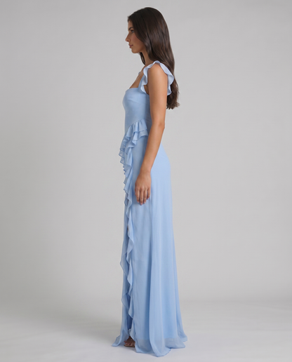 Side profile of light blue maxi dress with flutter sleeves, fitted silhouette and ruffled slit skirt