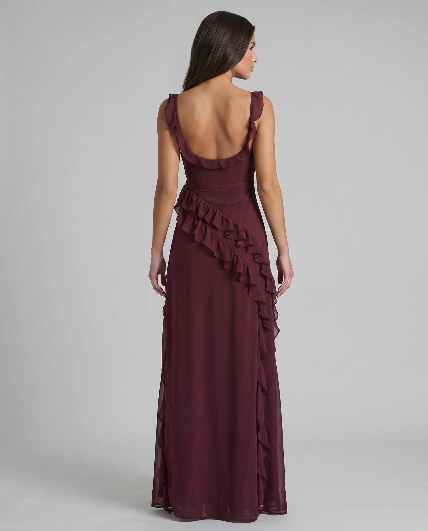 Back view of plum purple maxi dress with low scoop back, ruffle straps, and flowing skirt