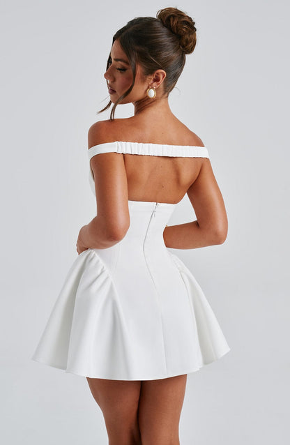 Back view of white off-shoulder mini dress with exposed center zipper and flared skirt silhouette