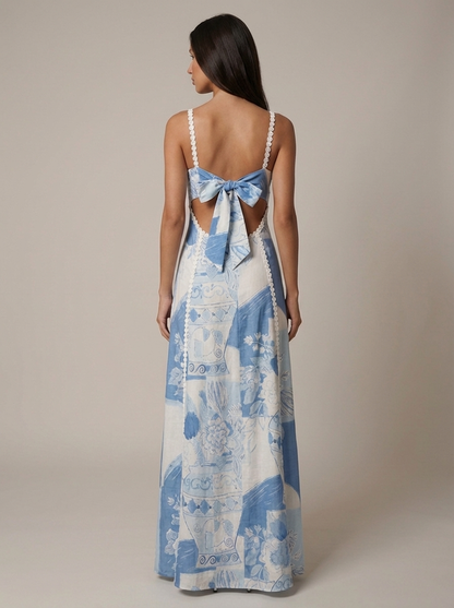 Full-length rear view of blue printed midi dress featuring open back, bow tie, and lace detailing