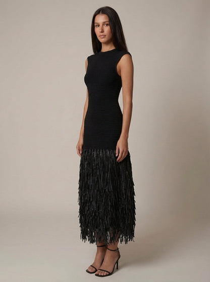 Three-quarter front shot of black fringe dress showing fitted waist and layered tassel hem