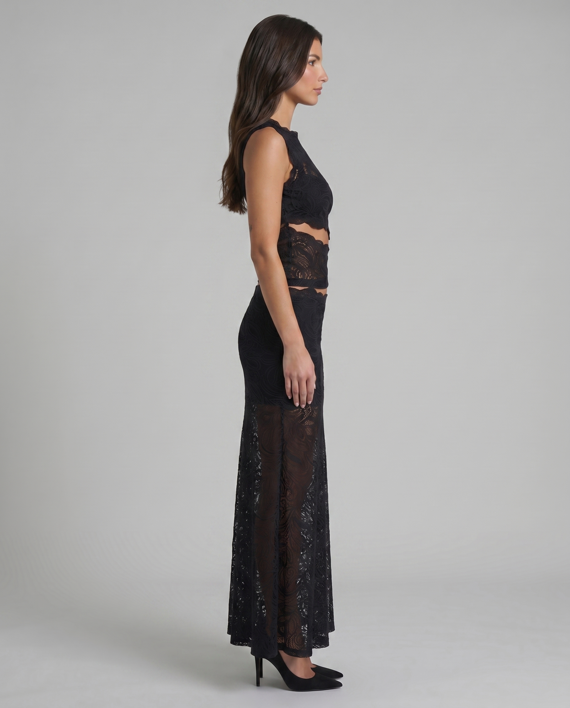 Side profile of black lace two-piece outfit showing fitted top and semi-sheer long skirt