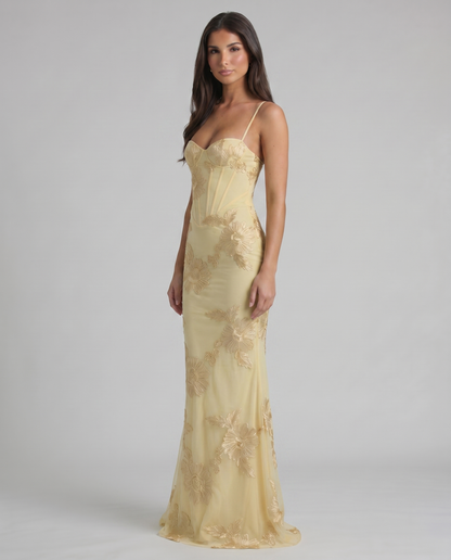 Three-quarter view of yellow embroidered maxi dress with bustier top and thin spaghetti straps
