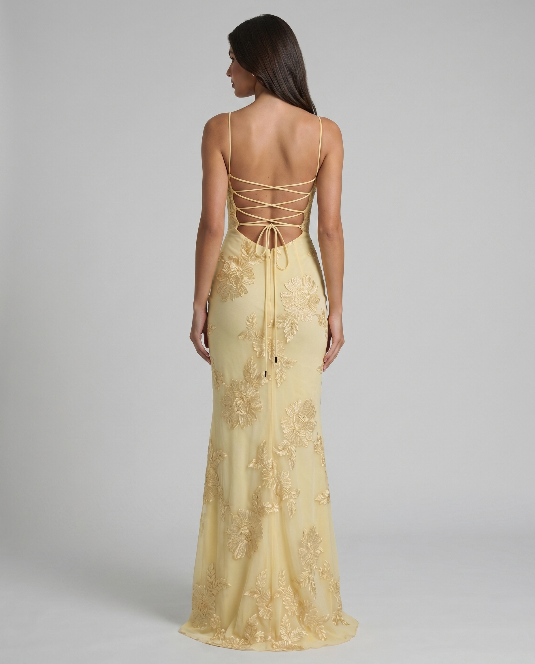 Back view of yellow maxi dress with crisscross lace-up open back and floral embroidery