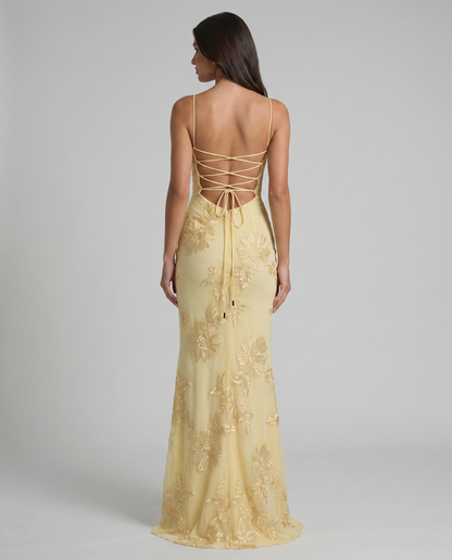 Close back view of yellow maxi dress showing lace-up detail, low back, and embroidered skirt