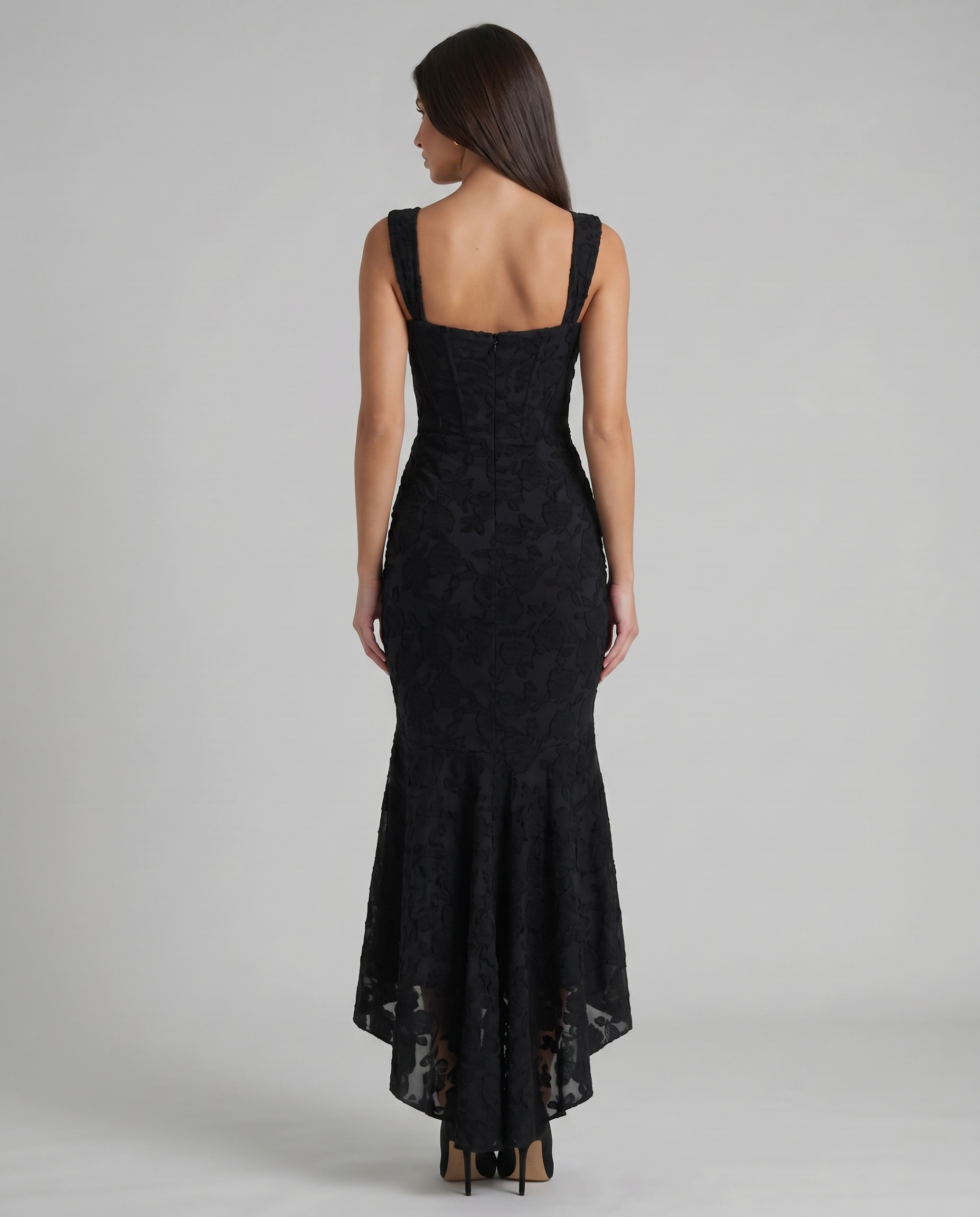 Back view of black corset maxi dress with square back neckline, wide straps, center zip and sheer hem