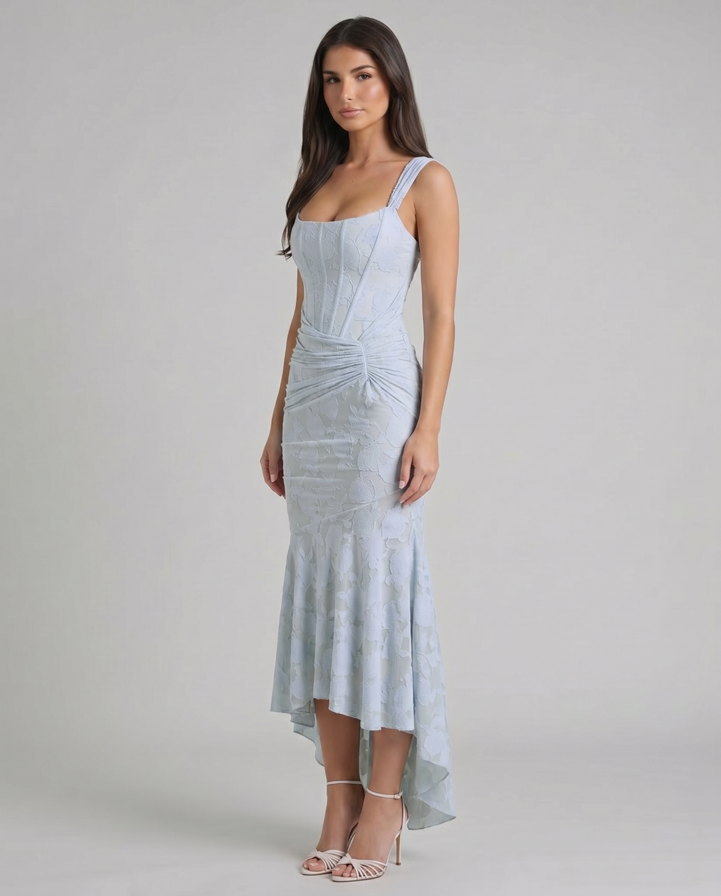 Three-quarter view of pale blue corset maxi dress with fitted bodice, draped ruching and high-low hem