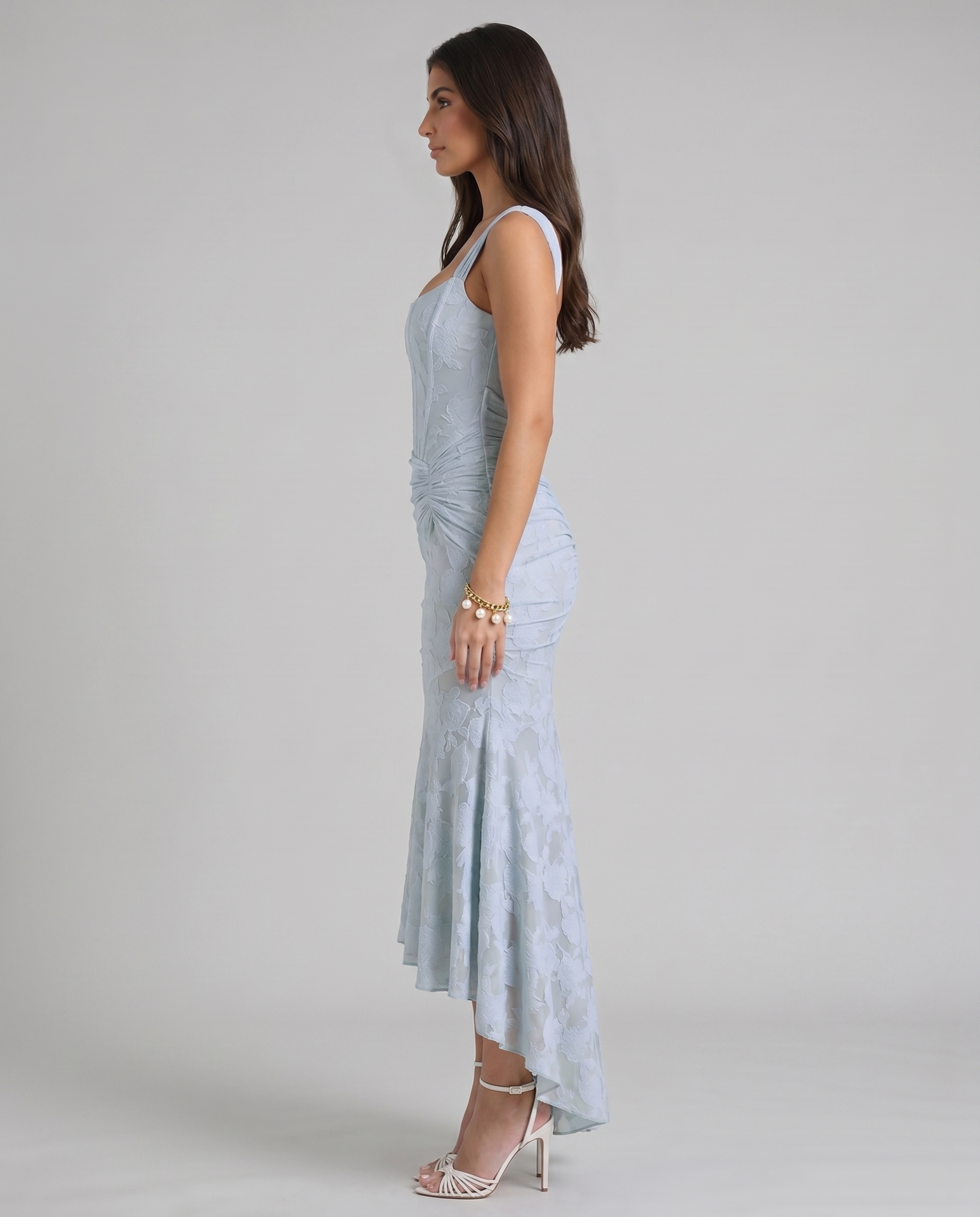 Side profile of blue corset maxi dress with sculpted bodice, gathered hip detail and flared skirt