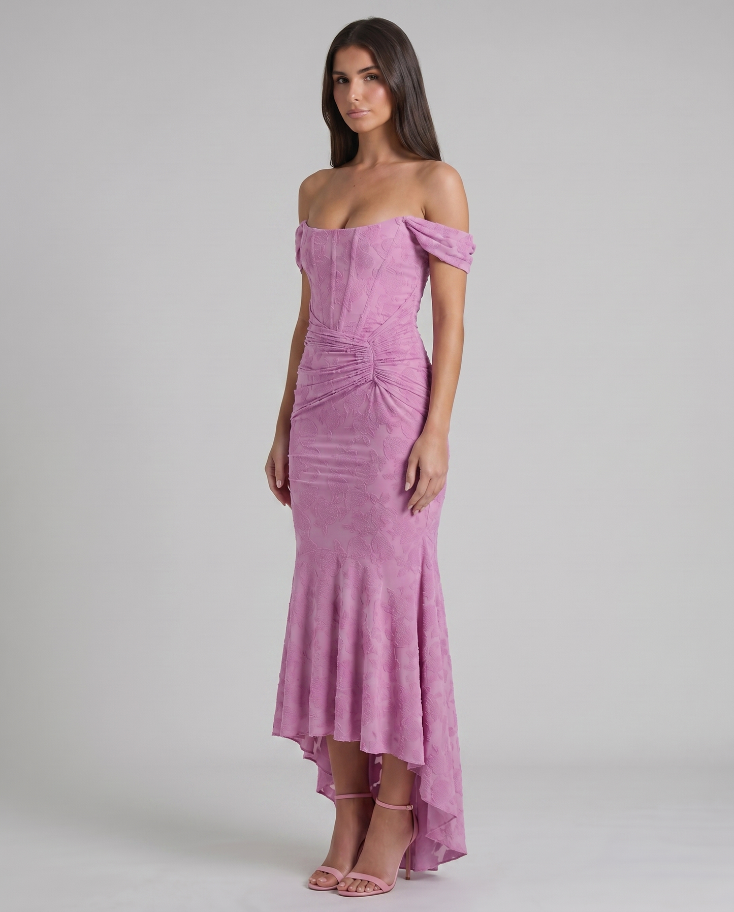 Three-quarter view pink corset maxi dress showing floral textured fabric, fitted bodice and draped ruching