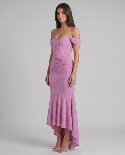 Three-quarter view pink corset maxi dress showing floral textured fabric, fitted bodice and draped ruching