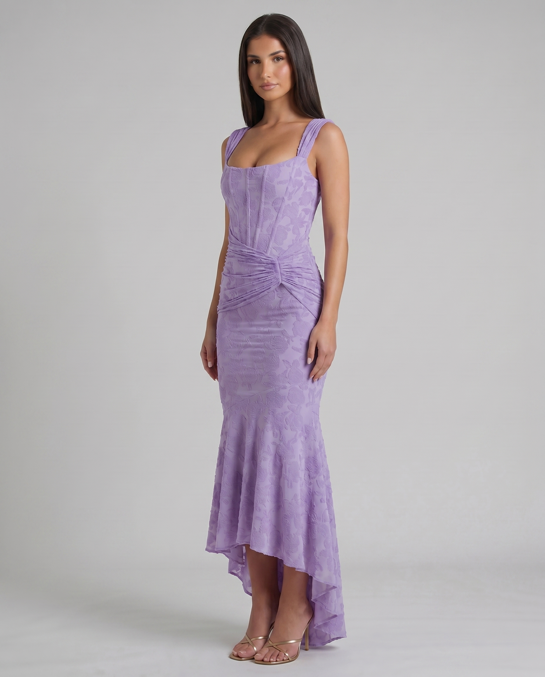 Three-quarter view of lavender corset maxi dress with textured floral fabric and draped waist detail