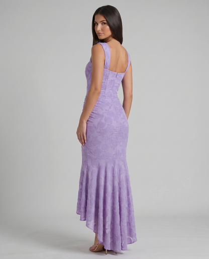 Back view of purple corset maxi dress with straight back neckline, fitted skirt and flared hem