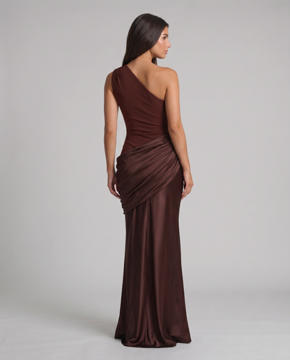 Back view of brown one-shoulder maxi dress with fitted waist and draped wrap-style skirt