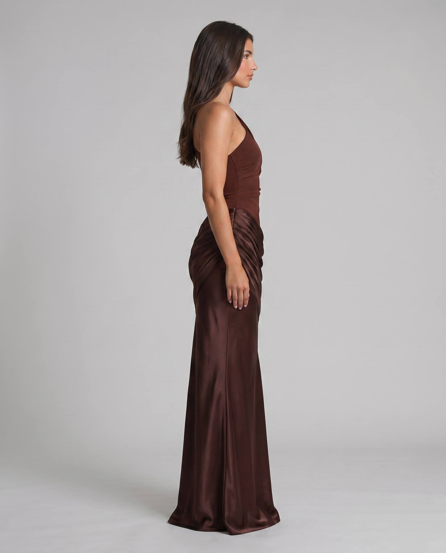 Side profile of brown satin maxi dress, one-shoulder neckline and gathered hip detailing