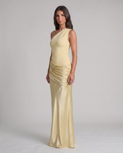 Three-quarter view of yellow one-shoulder maxi dress with satin ruched wrap detail at hips