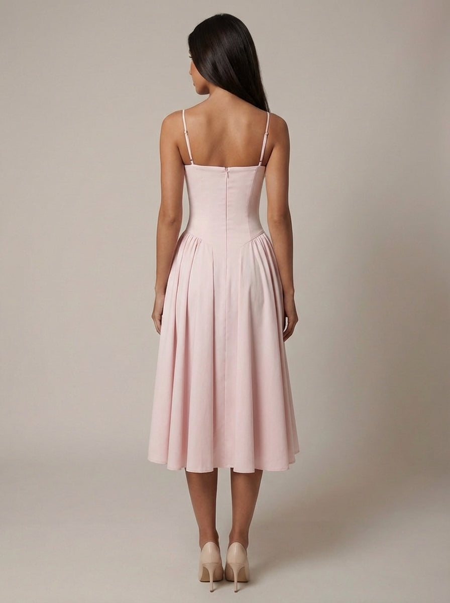 Back view of blush pink midi dress with adjustable spaghetti straps, fitted bodice, and midi-length flare