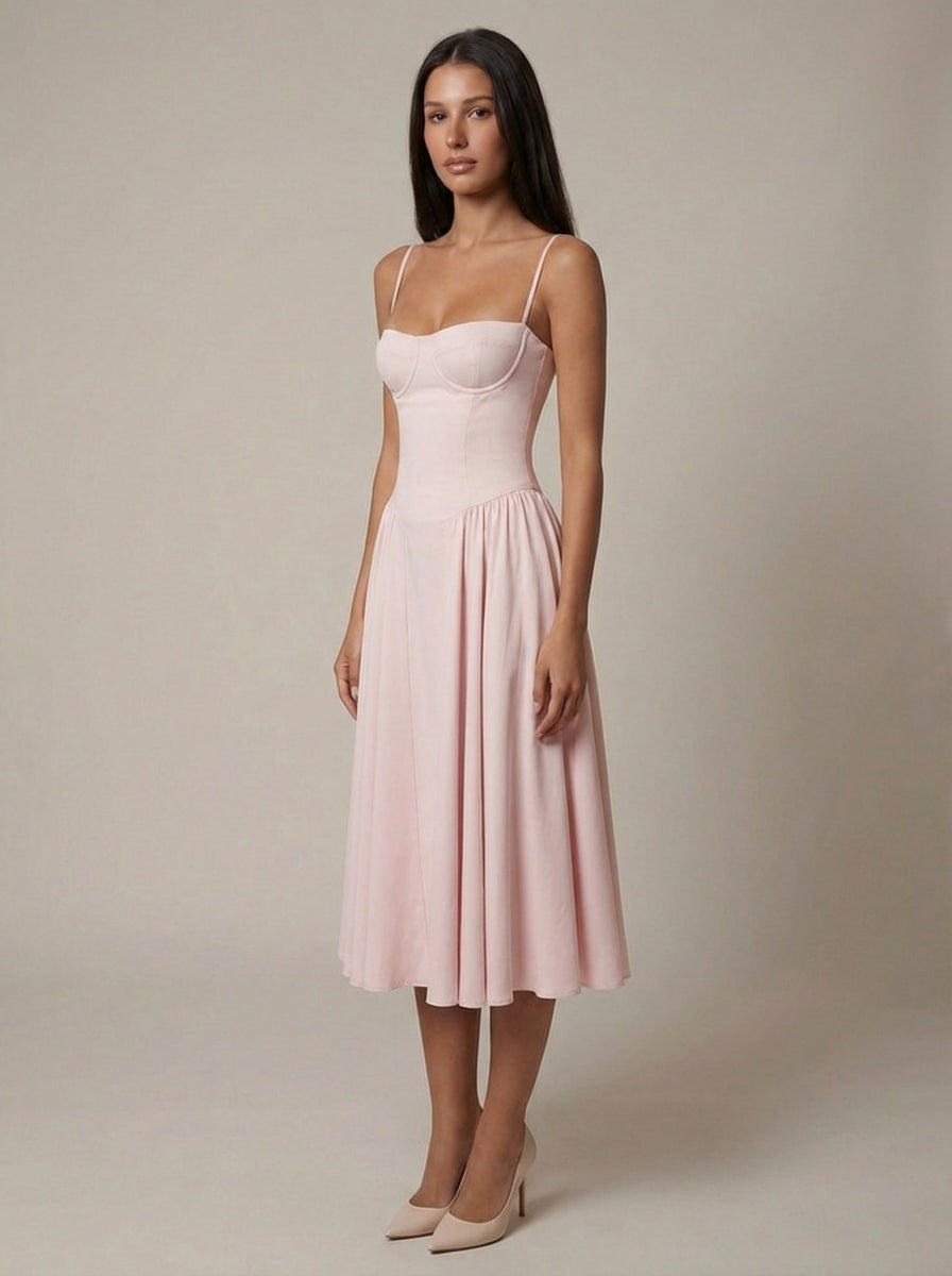 Three-quarter front view of blush pink midi dress with bustier top, defined waist, and flowing A-line skirt