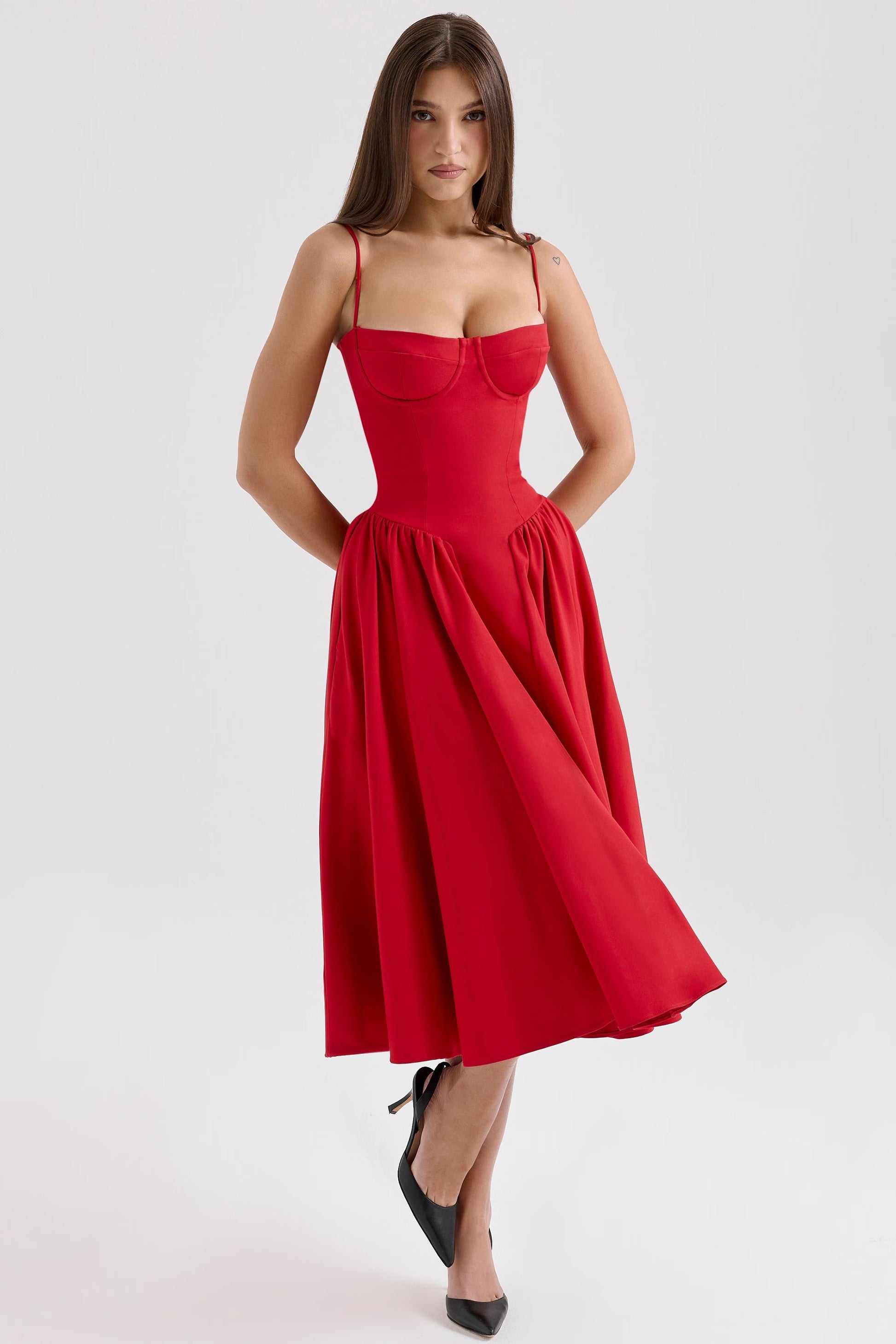 Front view of red midi dress showing bustier seams, thin straps and knee-length flared hem