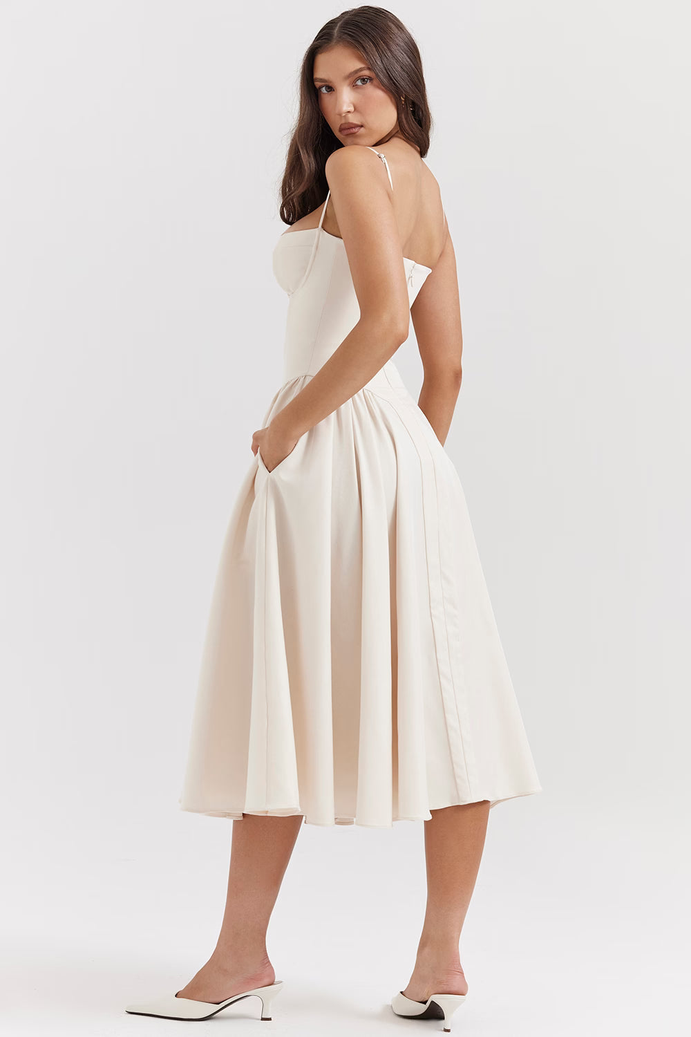Back three-quarter view of white midi dress with slim straps, fitted bodice and flared skirt