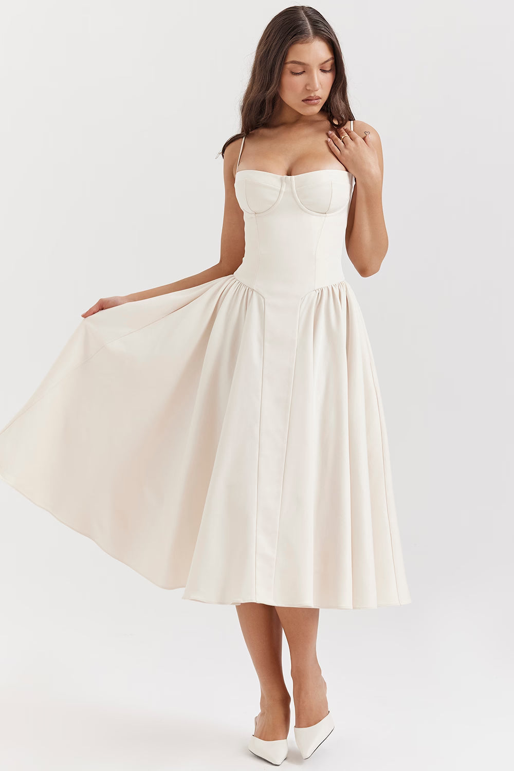 White midi dress with sweetheart bustier bodice and wide skirt held out to show volume and drape