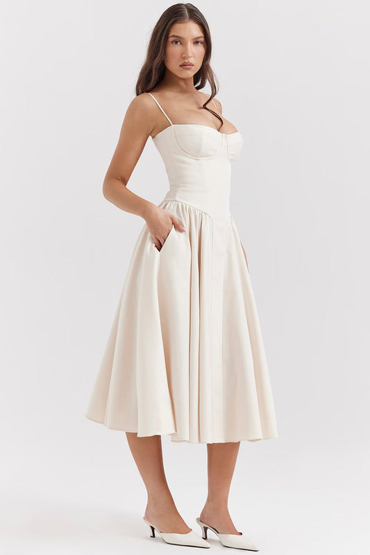 White midi dress with bustier neckline, spaghetti straps and full skirt with pockets, angled view
