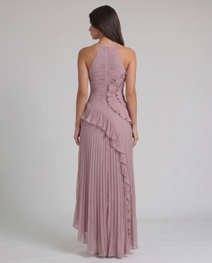 Back view of pink halter-neck maxi dress showing center zipper, pleated skirt, and ruffle accent at waist