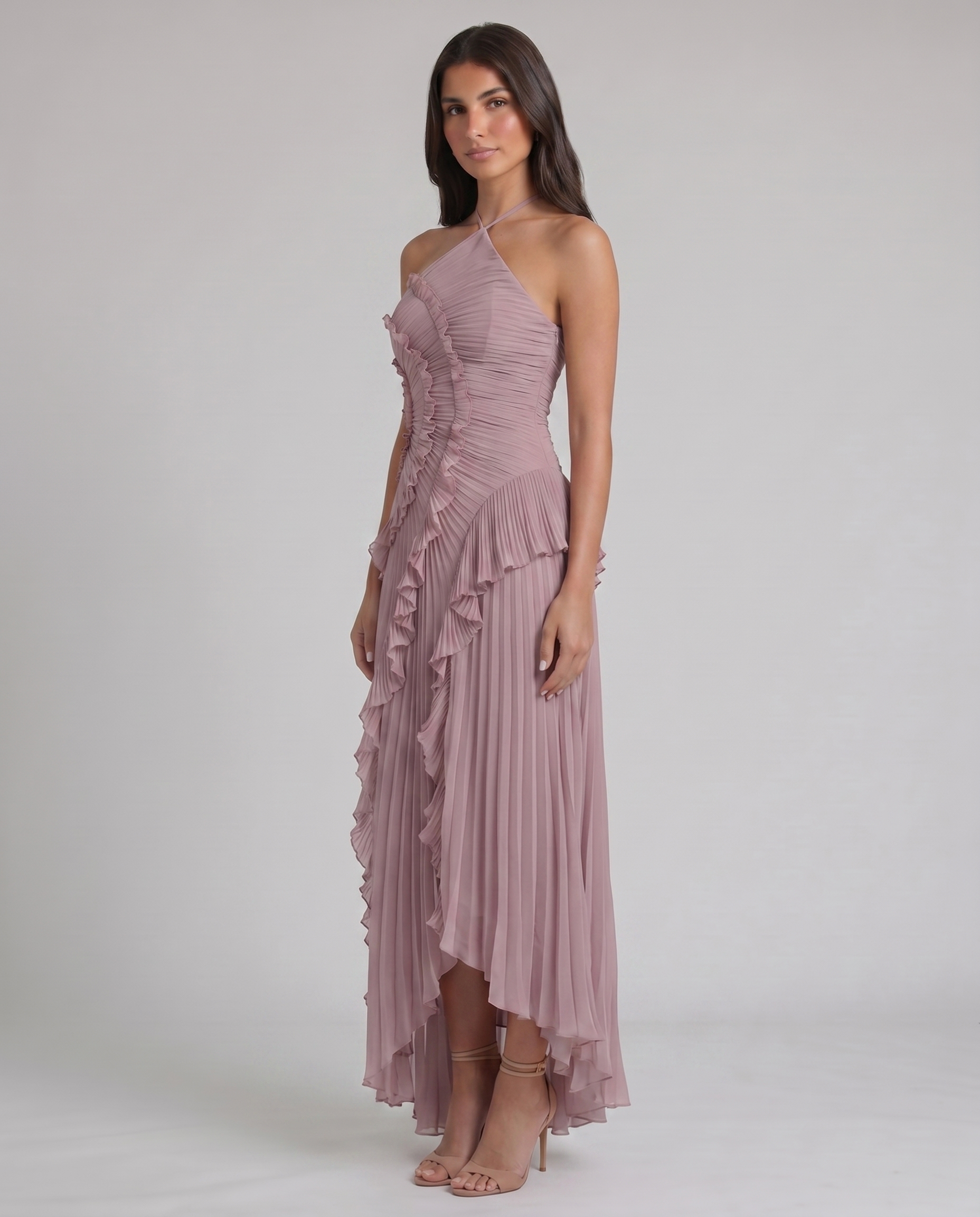Three-quarter view of pink chiffon maxi dress with ruched bodice, ruffle swirl detail, and pleated skirt