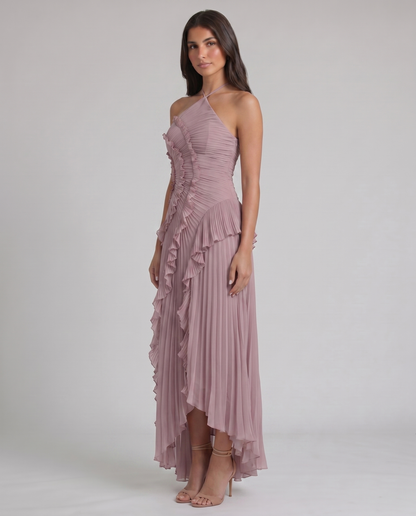 Three-quarter view of pink chiffon maxi dress with ruched bodice, ruffle swirl detail, and pleated skirt