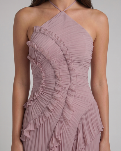 Close-up of pink halter maxi dress bodice with fine pleats, ruched texture, and stitched ruffle trim