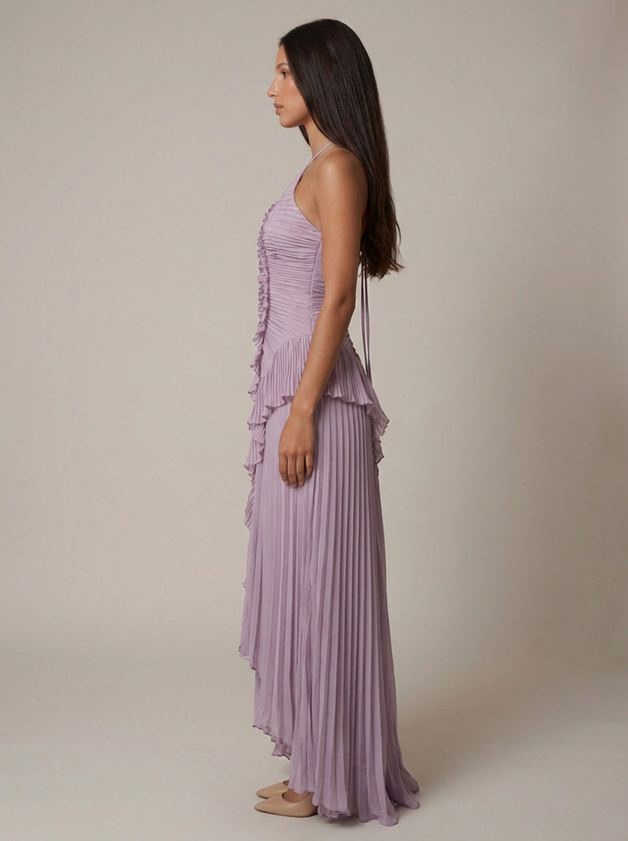 Full side view of purple halter maxi dress highlighting pleated skirt drape and asymmetrical hem