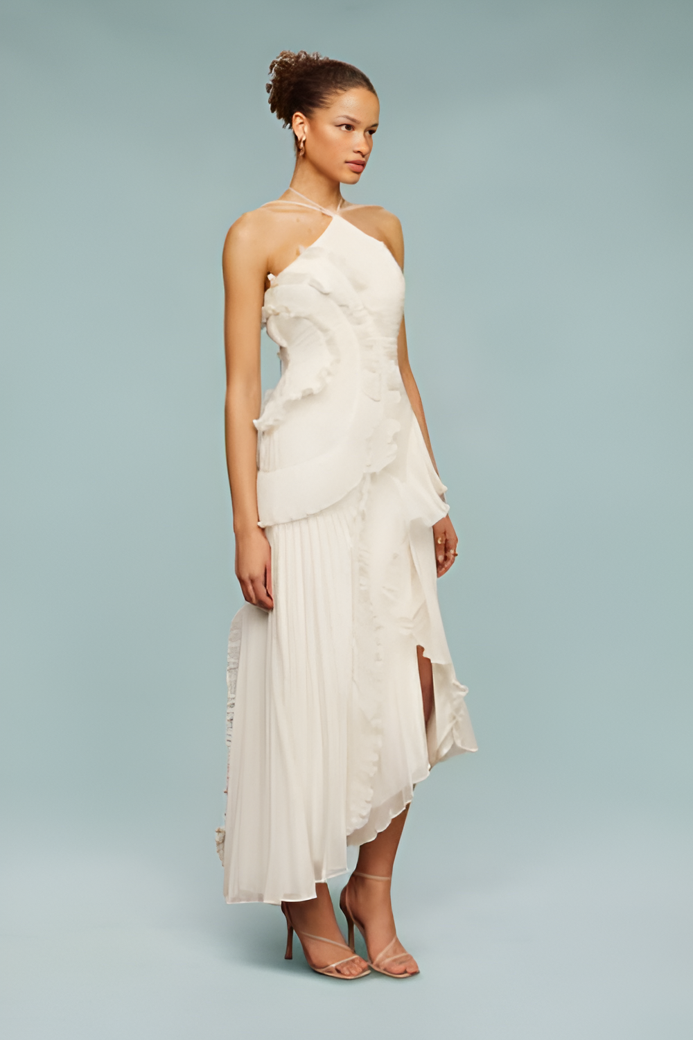Three-quarter side view of white maxi dress with statement ruffle overlay and pleated chiffon skirt