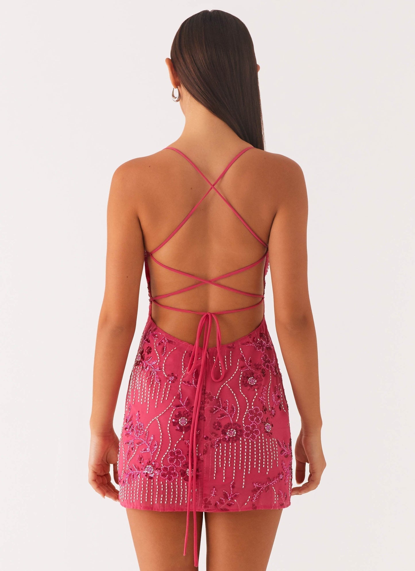 Back view fuchsia sequin mini dress with crisscross lace-up straps and low open back