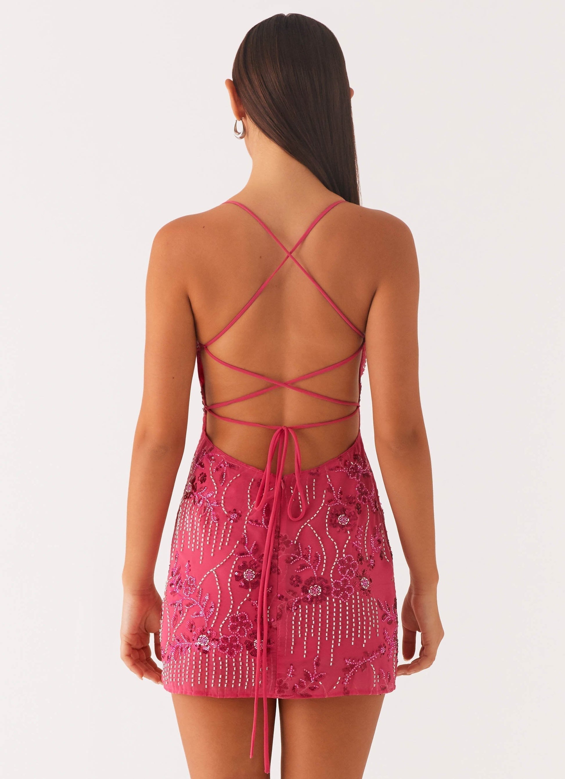 Back view fuchsia sequin mini dress with crisscross lace-up straps and low open back